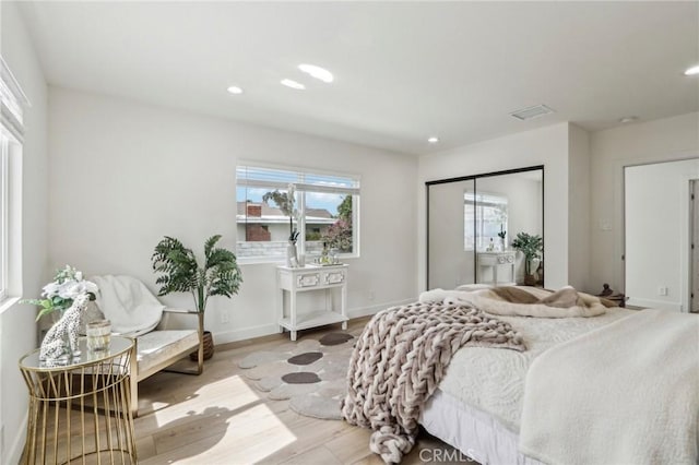 bedroom featuring visible vents, wood finished floors, recessed lighting, a closet, and baseboards