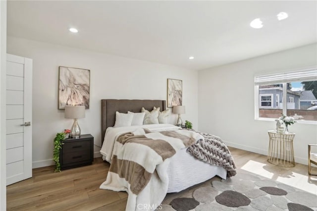 bedroom with recessed lighting, wood finished floors, and baseboards