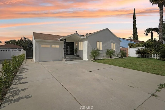 view of front facade featuring stucco siding, a garage, concrete driveway, and fence