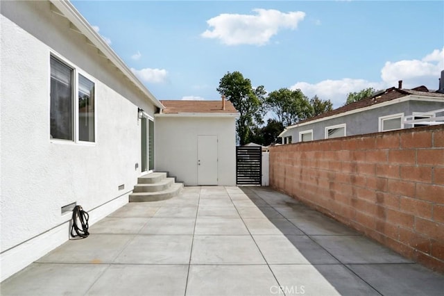 view of patio with a gate and fence