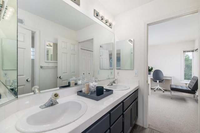 bathroom featuring a sink and double vanity