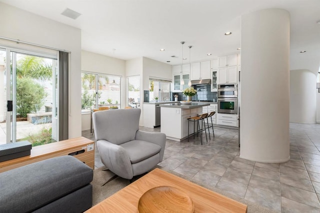 living area featuring light tile patterned flooring, recessed lighting, and visible vents