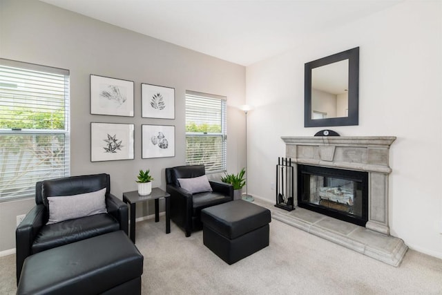 sitting room with carpet flooring, baseboards, and a glass covered fireplace