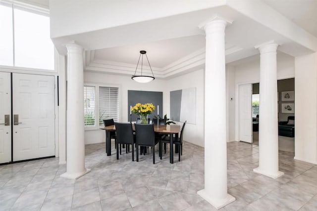 dining space featuring a raised ceiling, decorative columns, crown molding, and light tile patterned floors