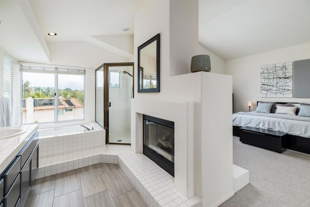 bedroom with vaulted ceiling, recessed lighting, a high end fireplace, and a sink