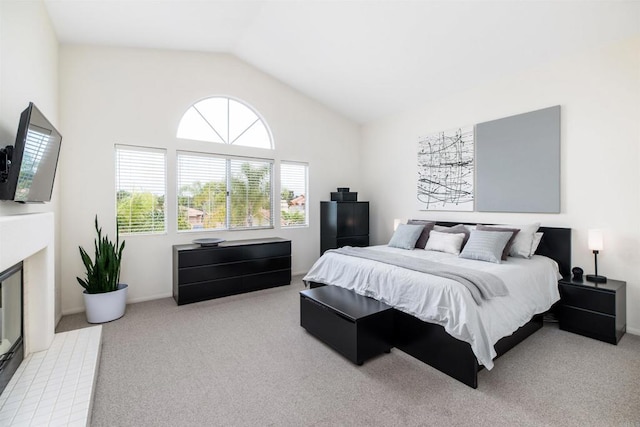 bedroom featuring baseboards, lofted ceiling, carpet floors, and a fireplace with flush hearth