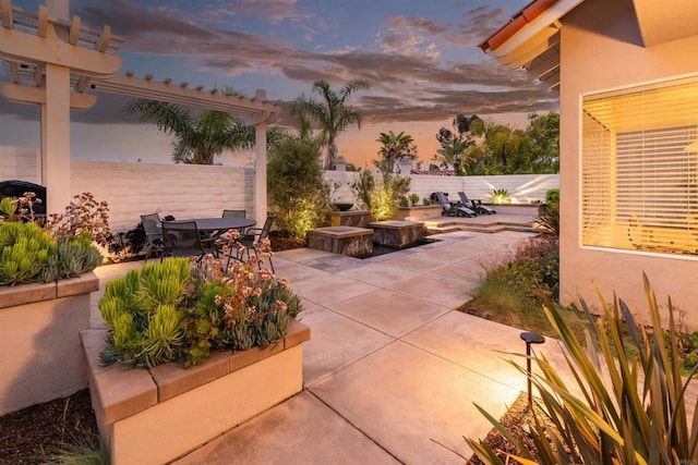 patio terrace at dusk with outdoor dining area and fence