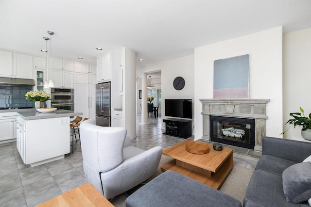 living area with recessed lighting, light tile patterned flooring, and a fireplace