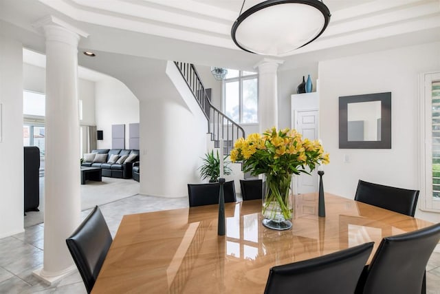 dining area featuring stairway and ornate columns