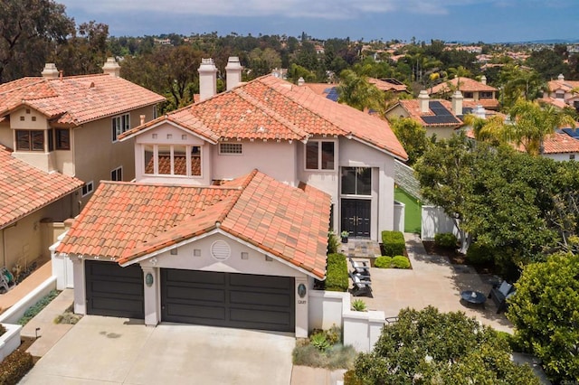 mediterranean / spanish home featuring a tile roof, fence private yard, and stucco siding