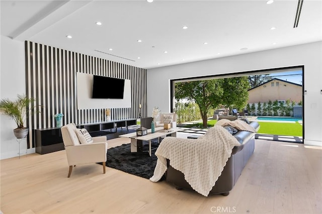 living room with recessed lighting, baseboards, and light wood-style floors