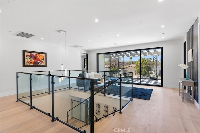 corridor featuring visible vents, an upstairs landing, wood finished floors, recessed lighting, and baseboards