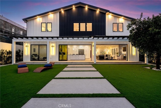 back of property with a lawn, board and batten siding, metal roof, and a standing seam roof