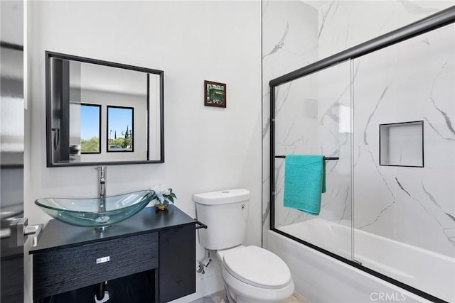 full bathroom featuring vanity, toilet, and combined bath / shower with glass door