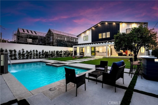 pool at dusk with a fenced in pool, a patio, a yard, and fence