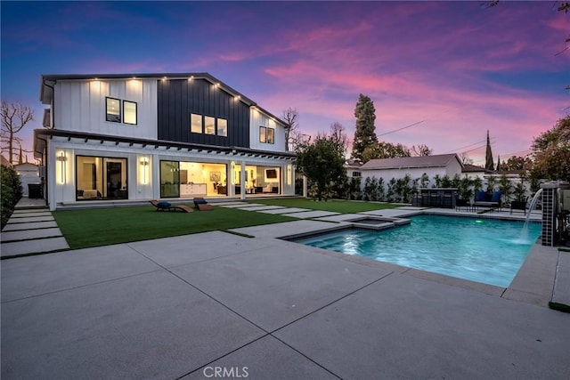 back of property featuring a patio, a lawn, board and batten siding, and fence