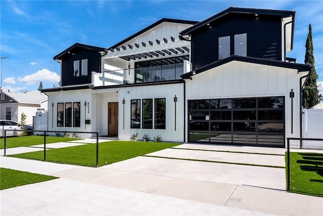 view of front of home featuring driveway, a balcony, board and batten siding, and a front yard