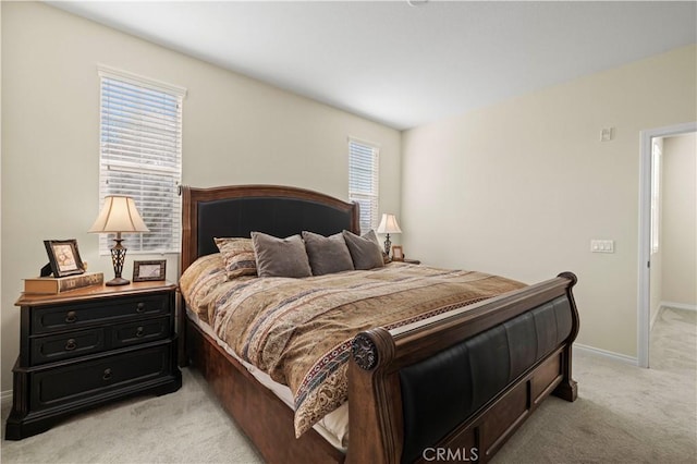 bedroom with baseboards and light colored carpet