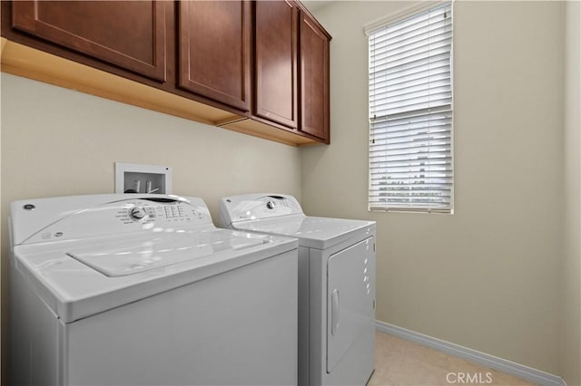 laundry room featuring baseboards, cabinet space, and washing machine and clothes dryer