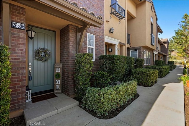 doorway to property with brick siding