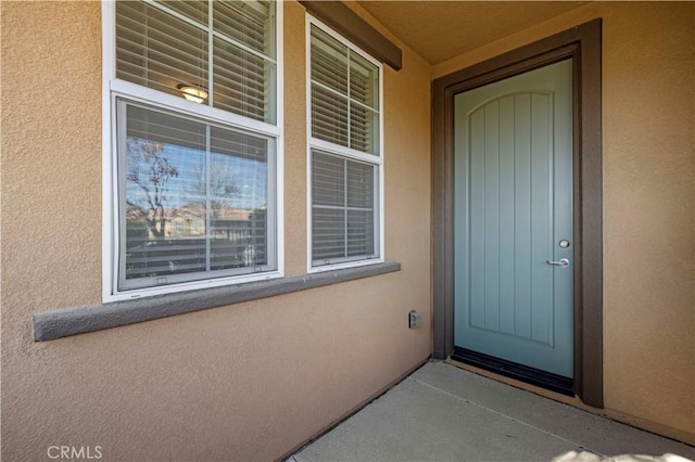 view of exterior entry featuring stucco siding