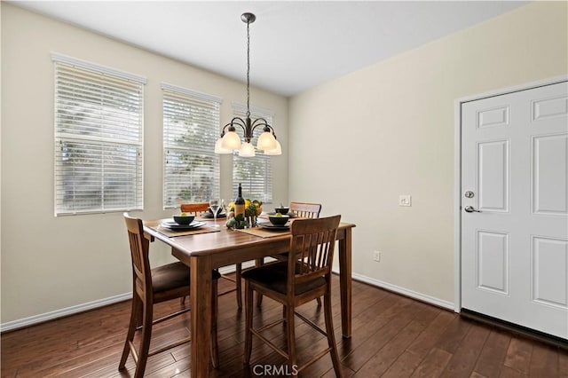 dining space featuring an inviting chandelier, dark wood-type flooring, and baseboards