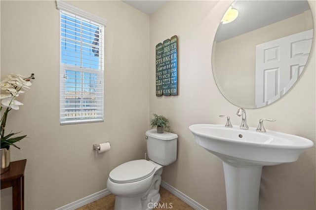 bathroom featuring toilet and baseboards