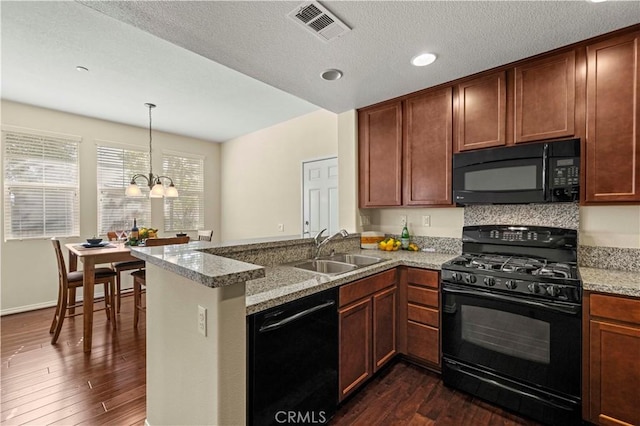 kitchen with visible vents, a peninsula, a sink, black appliances, and dark wood-type flooring