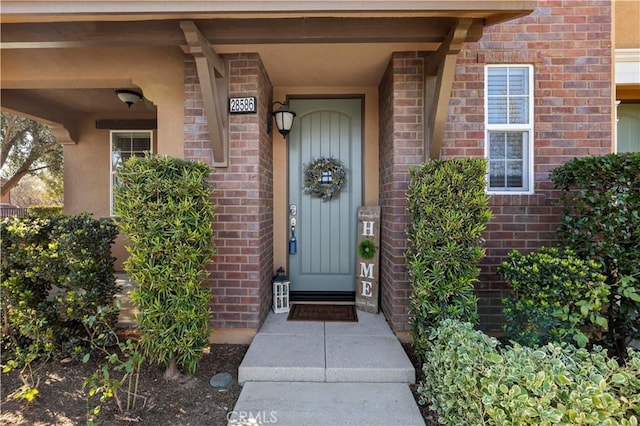 doorway to property featuring brick siding