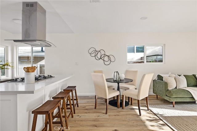 dining space with a wealth of natural light and light wood-type flooring