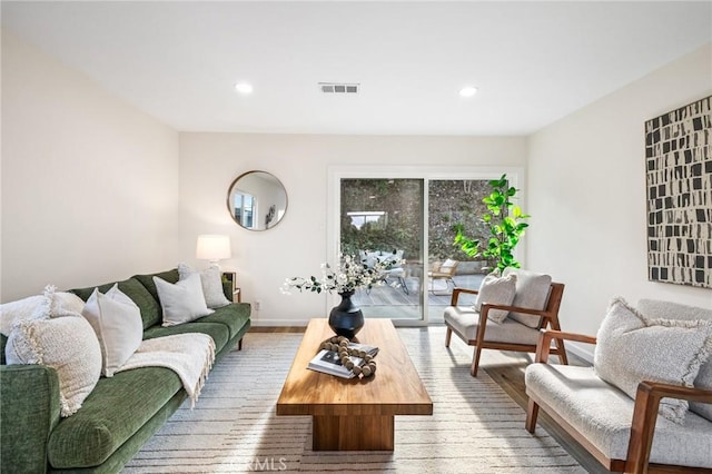 living area featuring recessed lighting, visible vents, baseboards, and wood finished floors