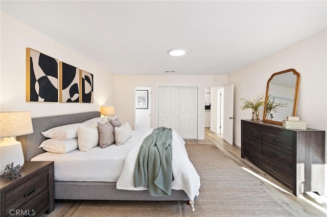 bedroom featuring a closet, visible vents, and wood finished floors