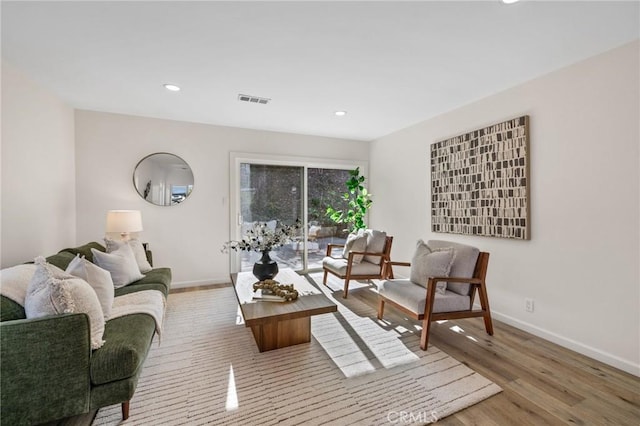 living room featuring recessed lighting, visible vents, baseboards, and wood finished floors