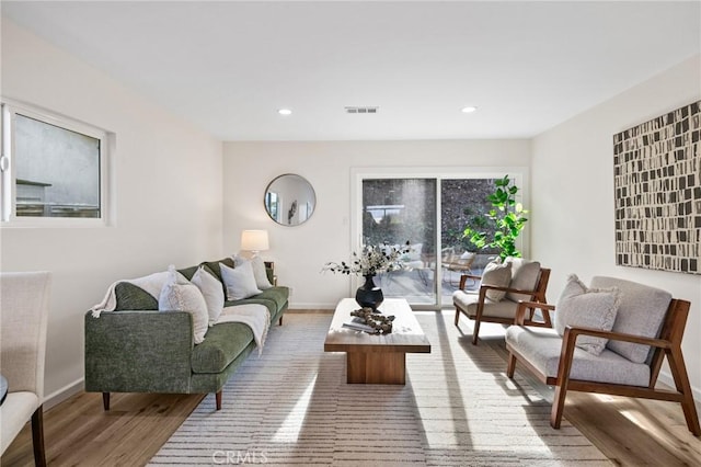 living area with visible vents, recessed lighting, baseboards, and wood finished floors