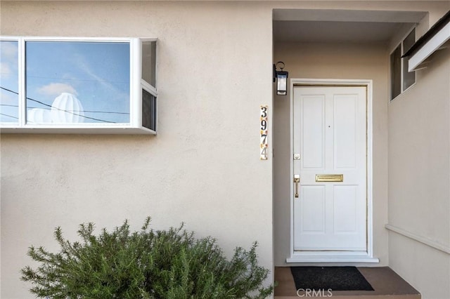 view of exterior entry featuring stucco siding