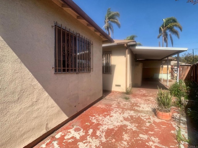 exterior space with crawl space, a patio area, fence, and stucco siding