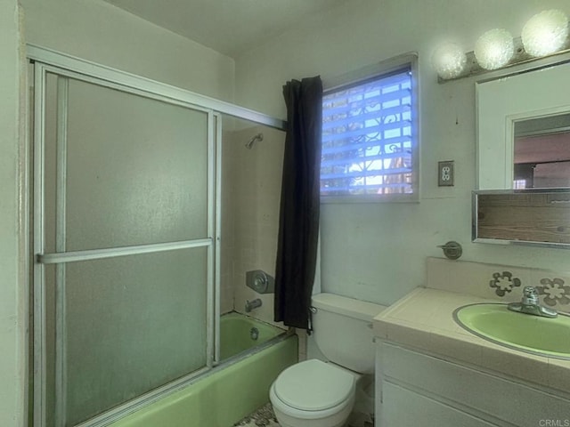 full bath featuring vanity, toilet, and shower / bath combination with glass door