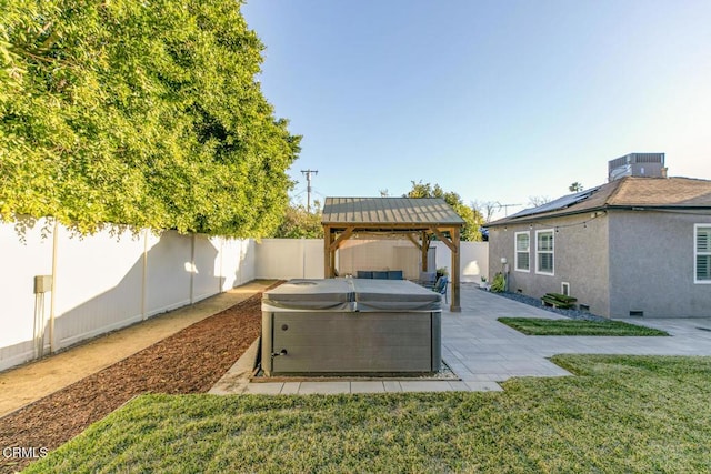 view of yard with a hot tub, a fenced backyard, a gazebo, cooling unit, and a patio area