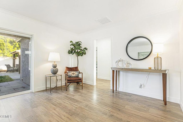 living area with ornamental molding, baseboards, and wood finished floors