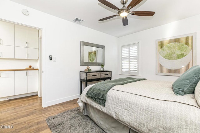 bedroom with light wood-style flooring, baseboards, visible vents, and ceiling fan