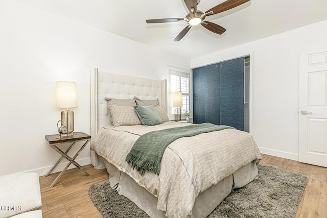 bedroom featuring a ceiling fan, light wood-type flooring, and baseboards