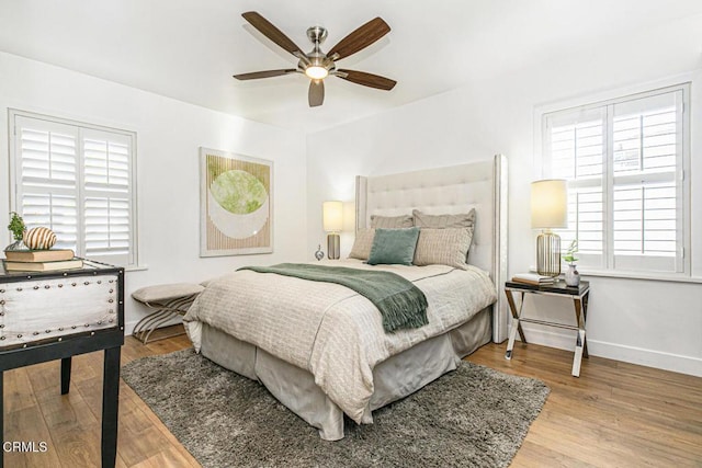 bedroom featuring ceiling fan, baseboards, and wood finished floors