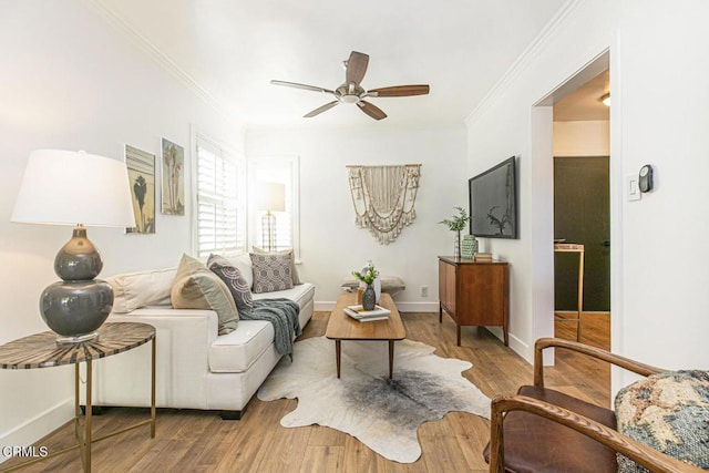 living room featuring ornamental molding, baseboards, ceiling fan, and wood finished floors