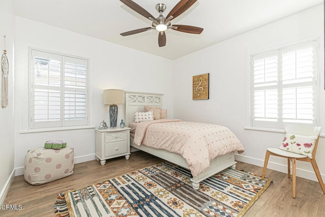 bedroom featuring wood finished floors, baseboards, and ceiling fan