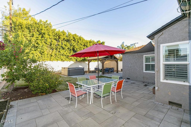 view of patio with outdoor dining area, a fenced backyard, and a hot tub