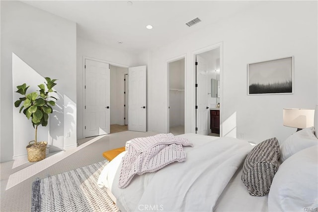 bedroom featuring carpet, visible vents, a spacious closet, a closet, and connected bathroom