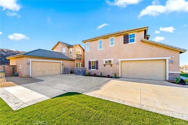 view of front of house with stucco siding, concrete driveway, and a front yard