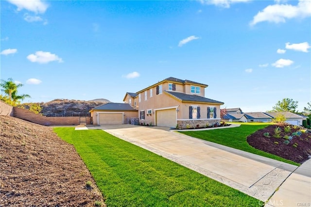 traditional home featuring a front yard, fence, driveway, an attached garage, and stucco siding