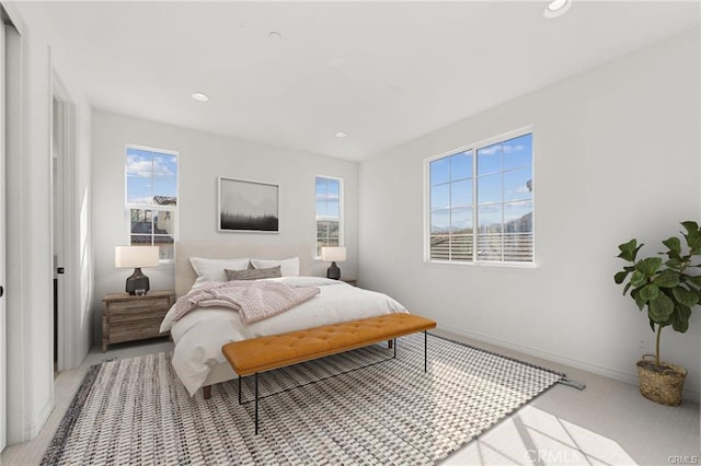 bedroom featuring light carpet, recessed lighting, multiple windows, and baseboards