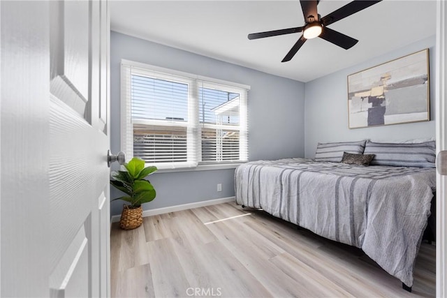 bedroom with ceiling fan, baseboards, and wood finished floors